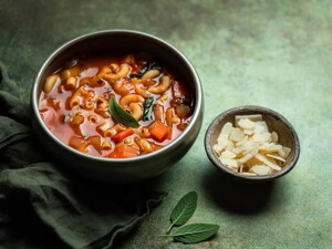 Un plato que contiene sopa de vegetales con pasta de fideo