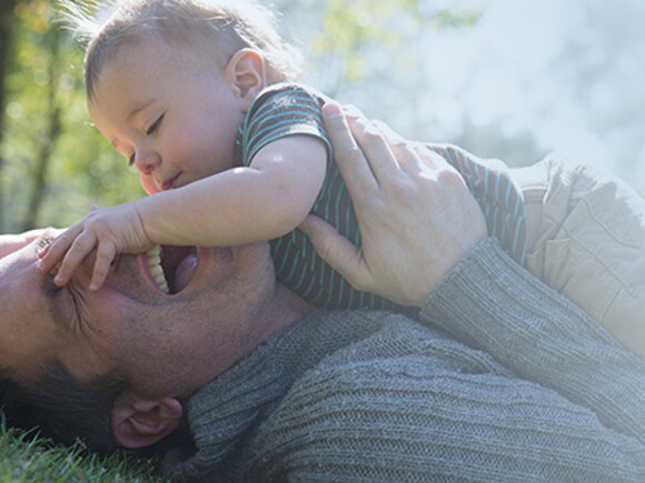 Bebé encima de su padre riendose