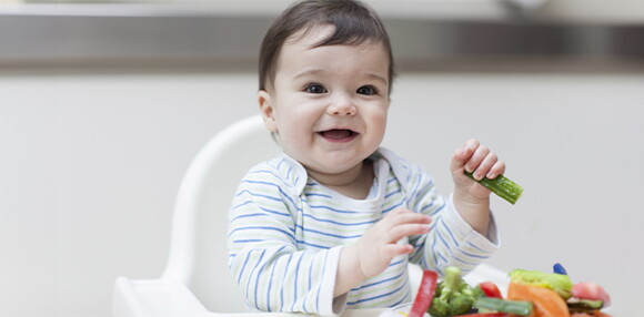 Bebé de 9 meses cogiendo alimentos sólidos