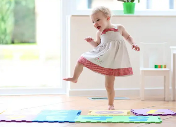 niña bailando sobre tapetes de goma para jugar