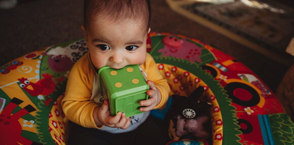 Niño sentado cogiendo un juguete.